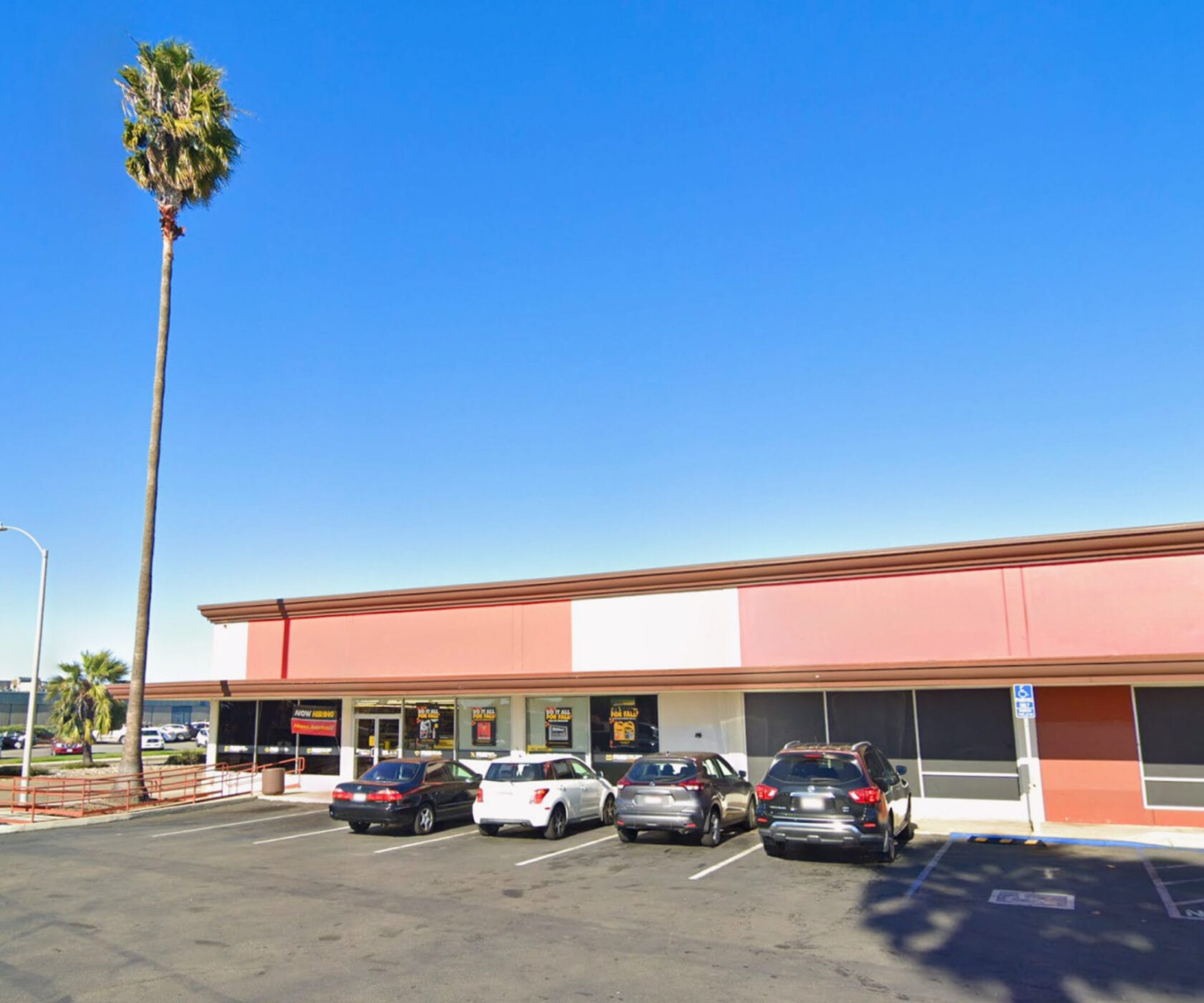 Front building facade of 2041 Mission Ave viewed from the parking lot with Mission Ave visible to the left.