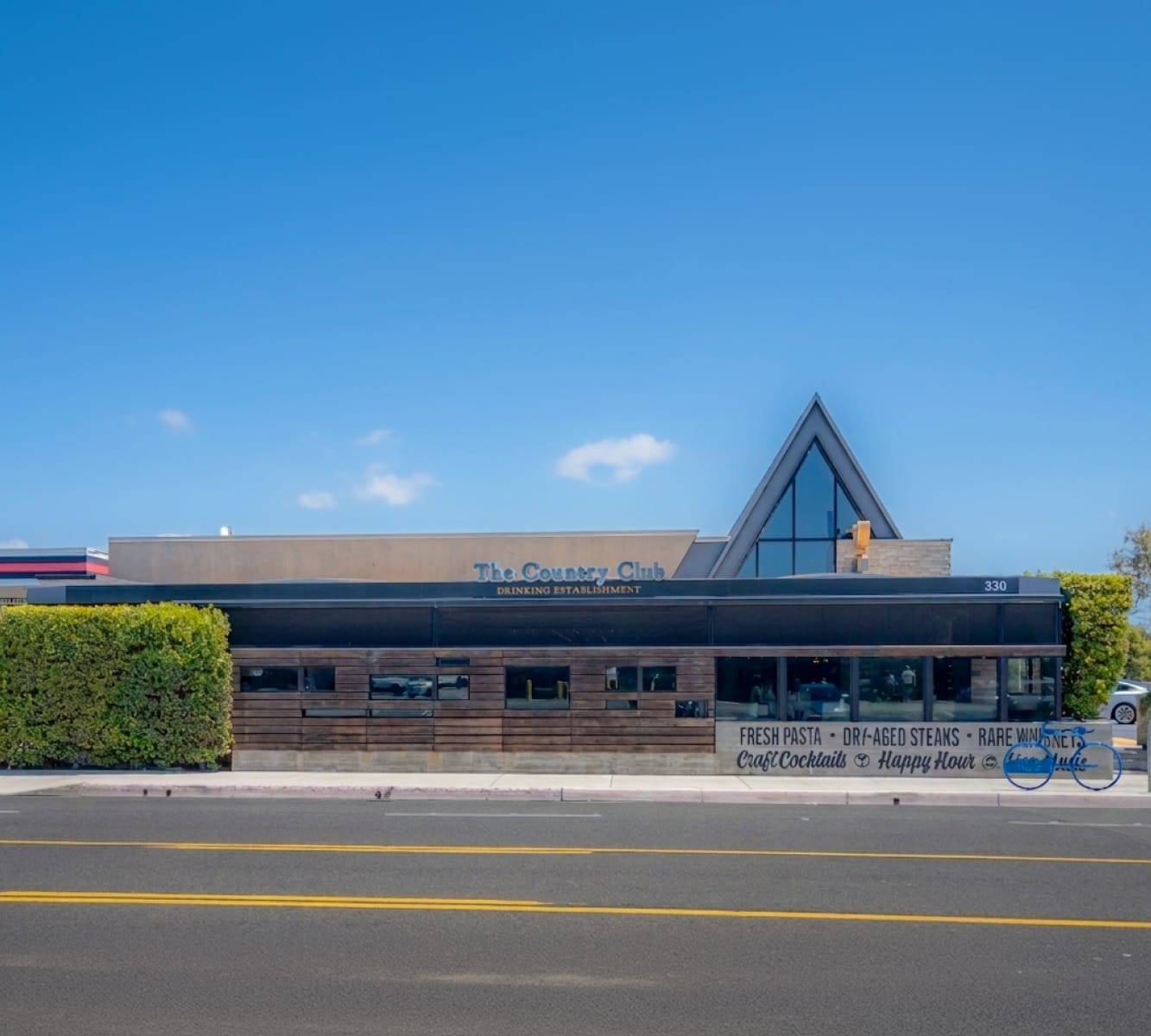 Exterior view of The Country Club building in Costa Mesa. Brown building, single story