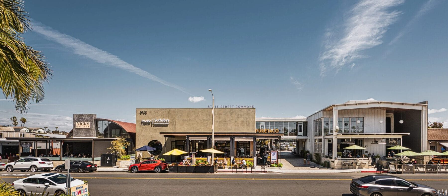 Coastal storefronts featuring a variety of retail shops with palm trees surrounding