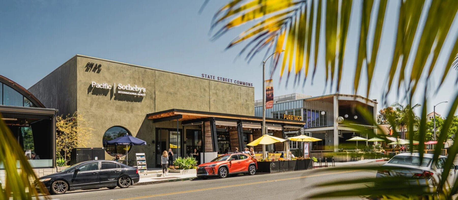 Coastal storefronts featuring a variety of retail shops with palm trees surrounding