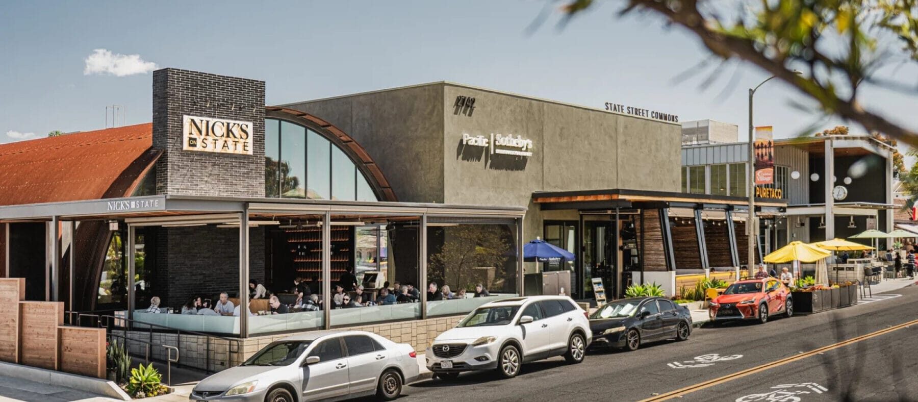 Coastal storefronts featuring a variety of retail shops with palm trees surrounding