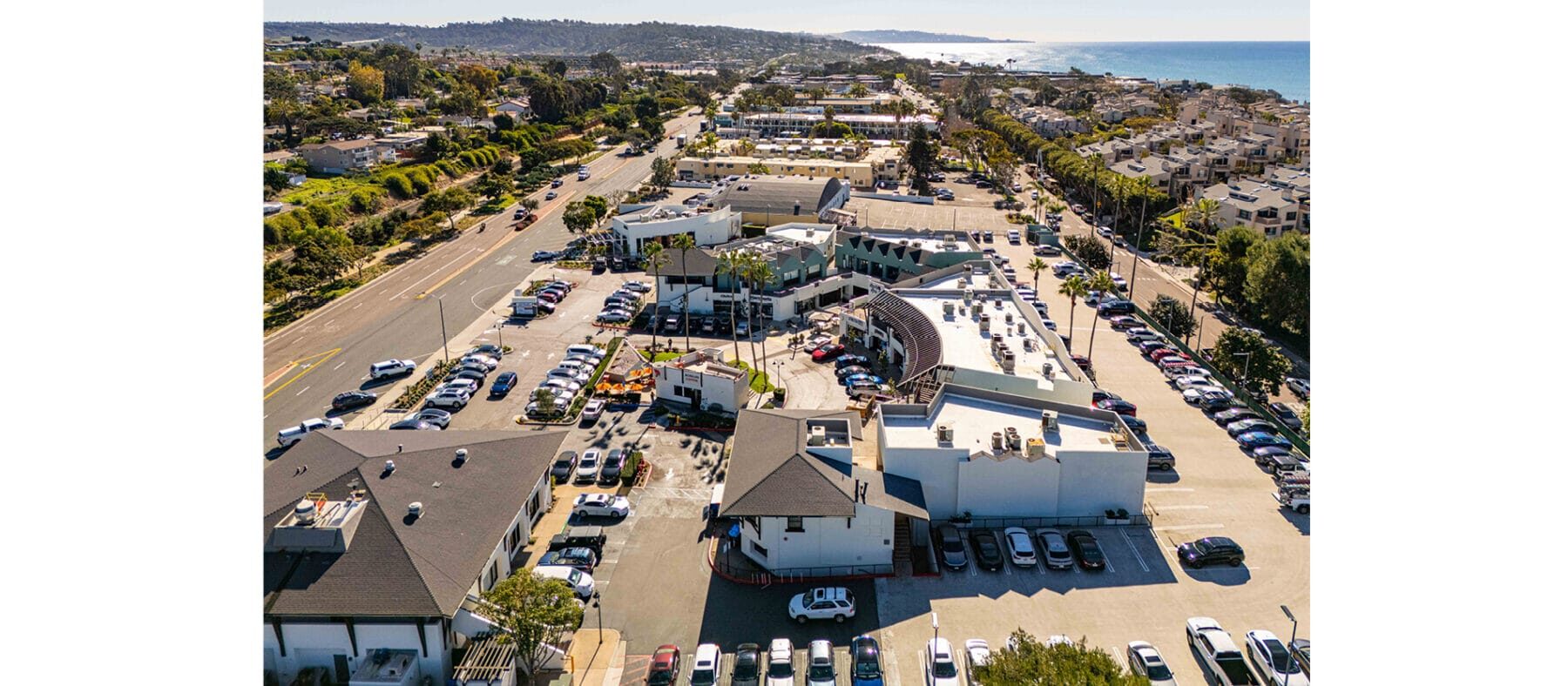 Aerial view of a beach with a shopping center below
