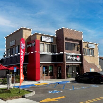 The building at 1621 Grand Ave viewed from the parking lot entrance off of Grand Ave. Wendy's and its outdoor dining are on the first level, and the office spaces are on the 2nd level. Onsite parking is in front of the 1st and 2nd floor's main entrances on the side of the building, while the front of the building faces Grand Ave.
