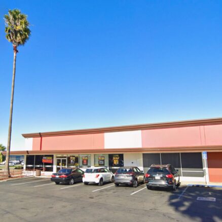 Front building facade of 2041 Mission Ave viewed from the parking lot with Mission Ave visible to the left.