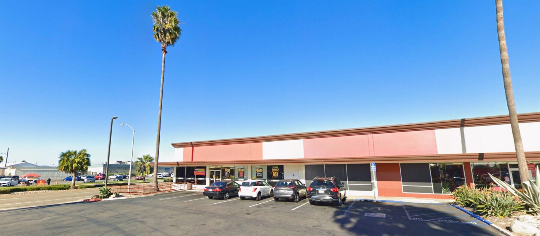Front building facade of 2041 Mission Ave viewed from the parking lot with Mission Ave visible to the left.