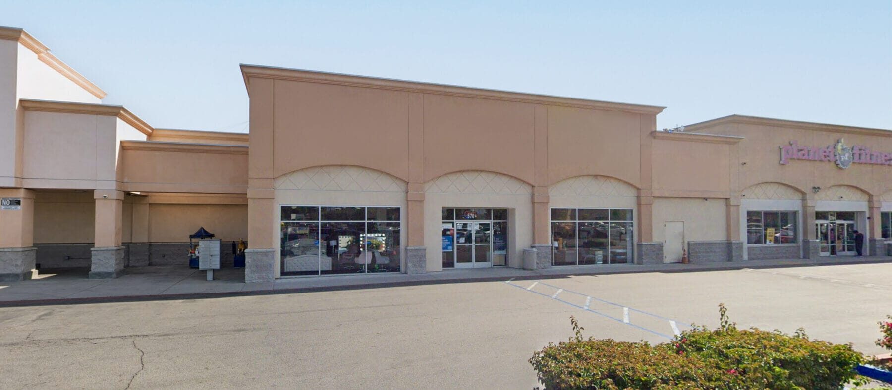A wide view of the front building facade of 570 S Mt Vernon Ave with Planet Fitness to the right