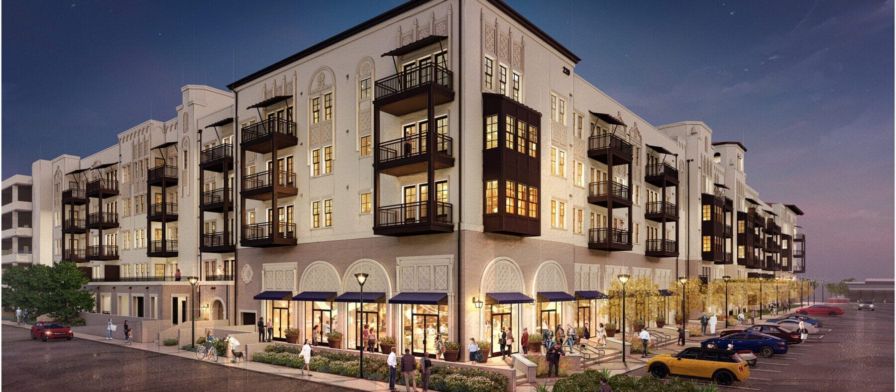 Several stories-high building with a sunset in the background. Building is white with some dark trim.