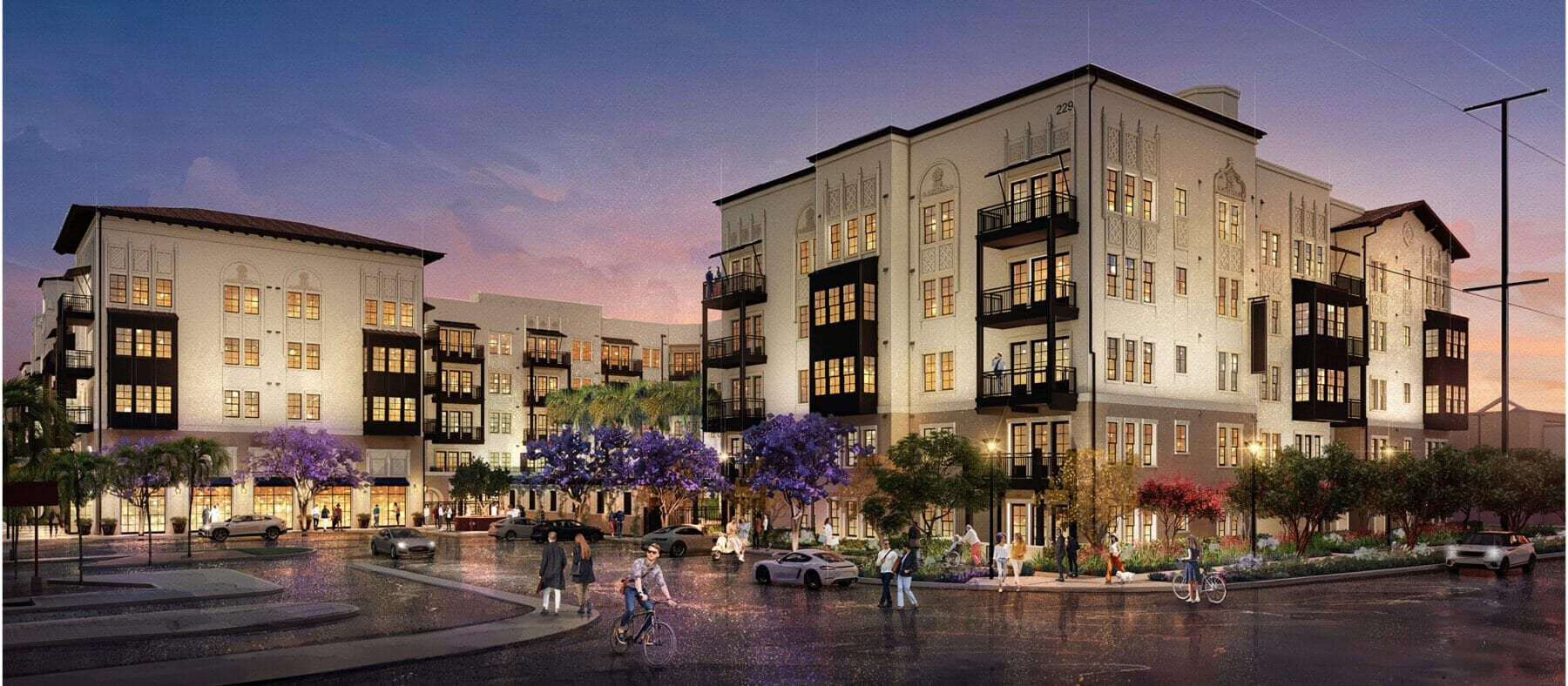 Several stories-high building with a sunset in the background. Building is white with some dark trim.