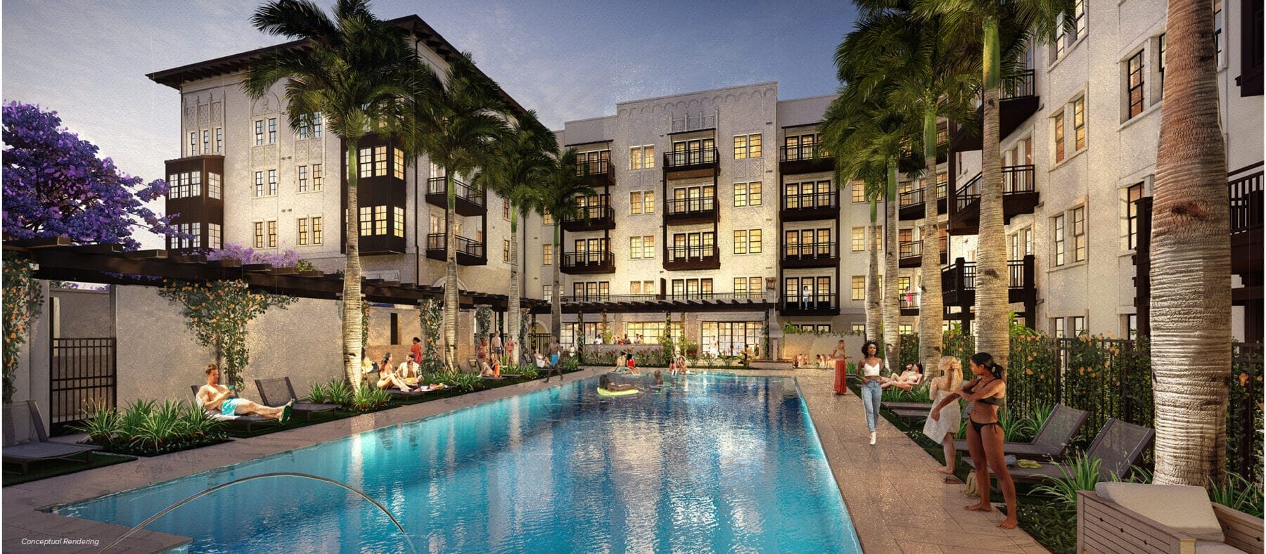 Several stories-high building with a sunset in the background. Building is white with some dark trim. Pool is in the foreground.