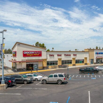 Former Grocery Outlet building at 350 N 2nd St with a large parking lot in front and Eyeglass World to the right.
