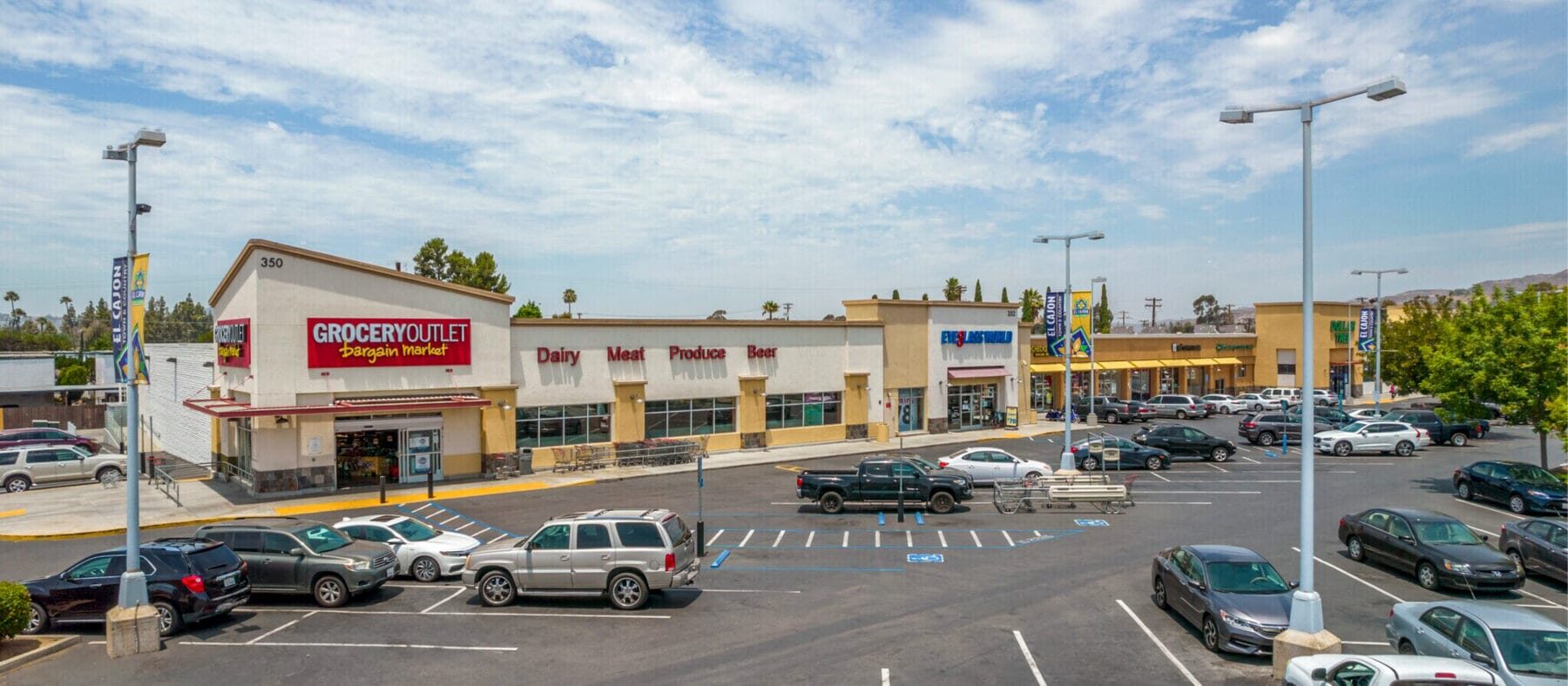 Former Grocery Outlet building at 350 N 2nd St with a large parking lot in front. To the right are Eyeglass World, Dollar Tree, and other shops in El Cajon Town & Country shopping center.