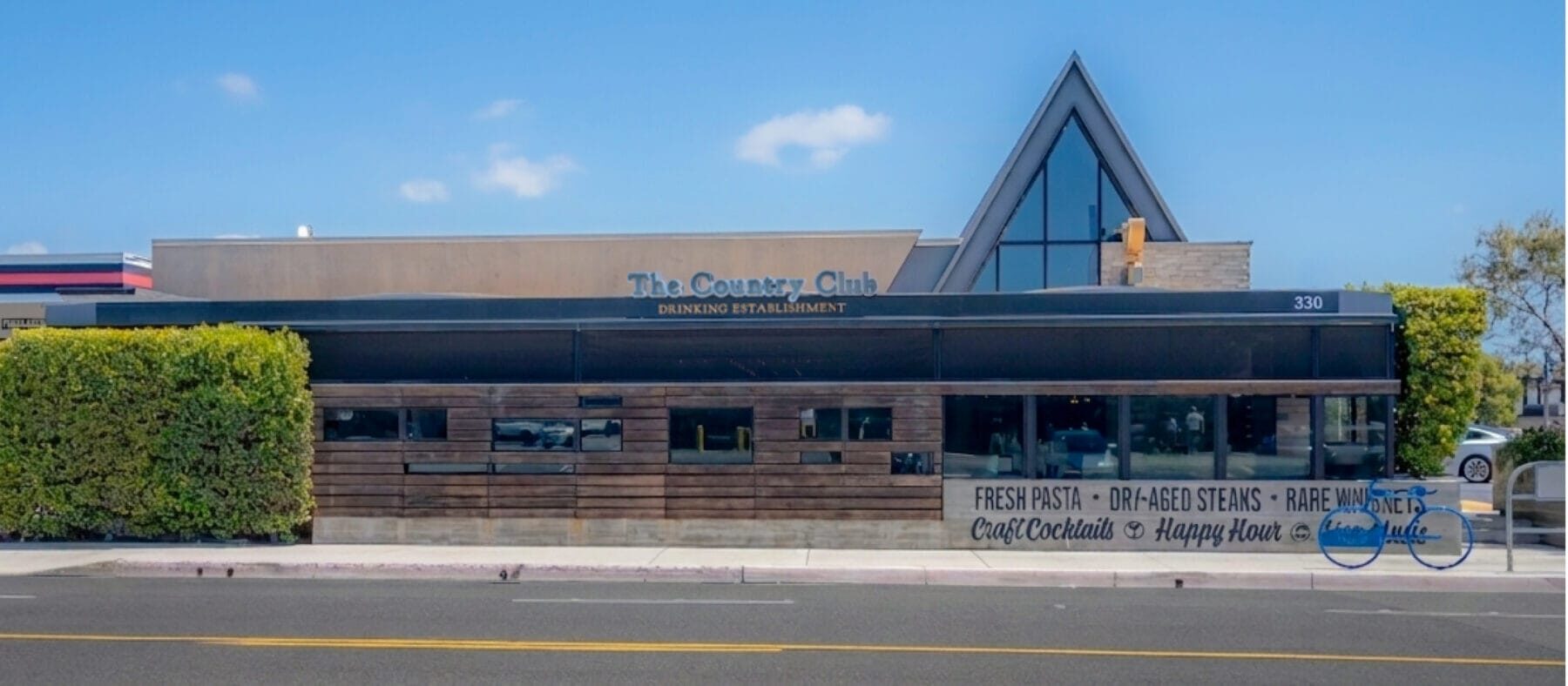 Exterior view of The Country Club building in Costa Mesa. Brown building, single story