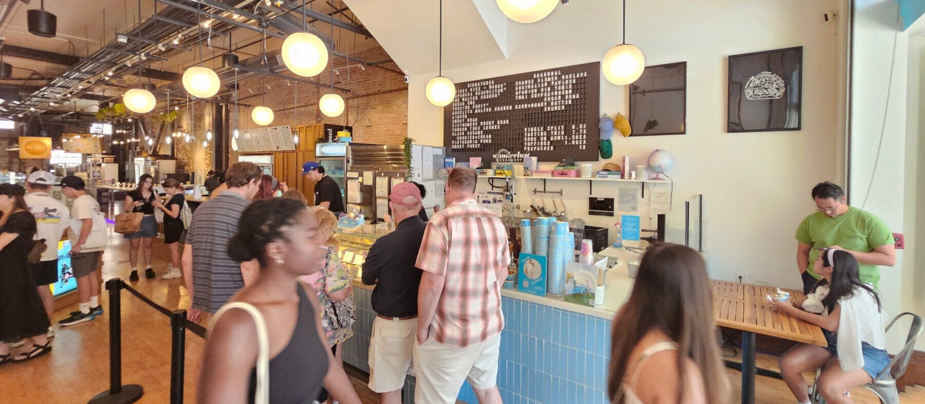 Inside of a coffee shop with lots of people walking around.