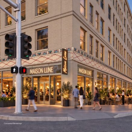 Rendering of multistory historic building at dusk with lots of people around and dining inside
