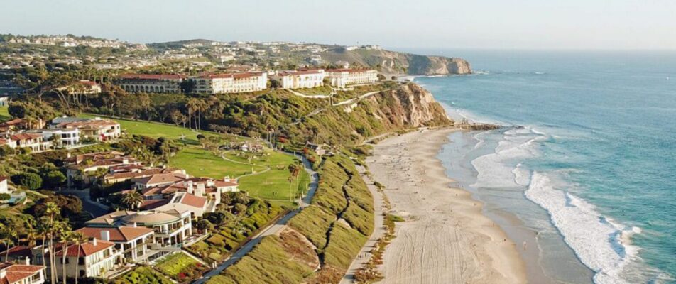 The title "Aliso Village" over an aerial of the Laguna Niguel coastline.