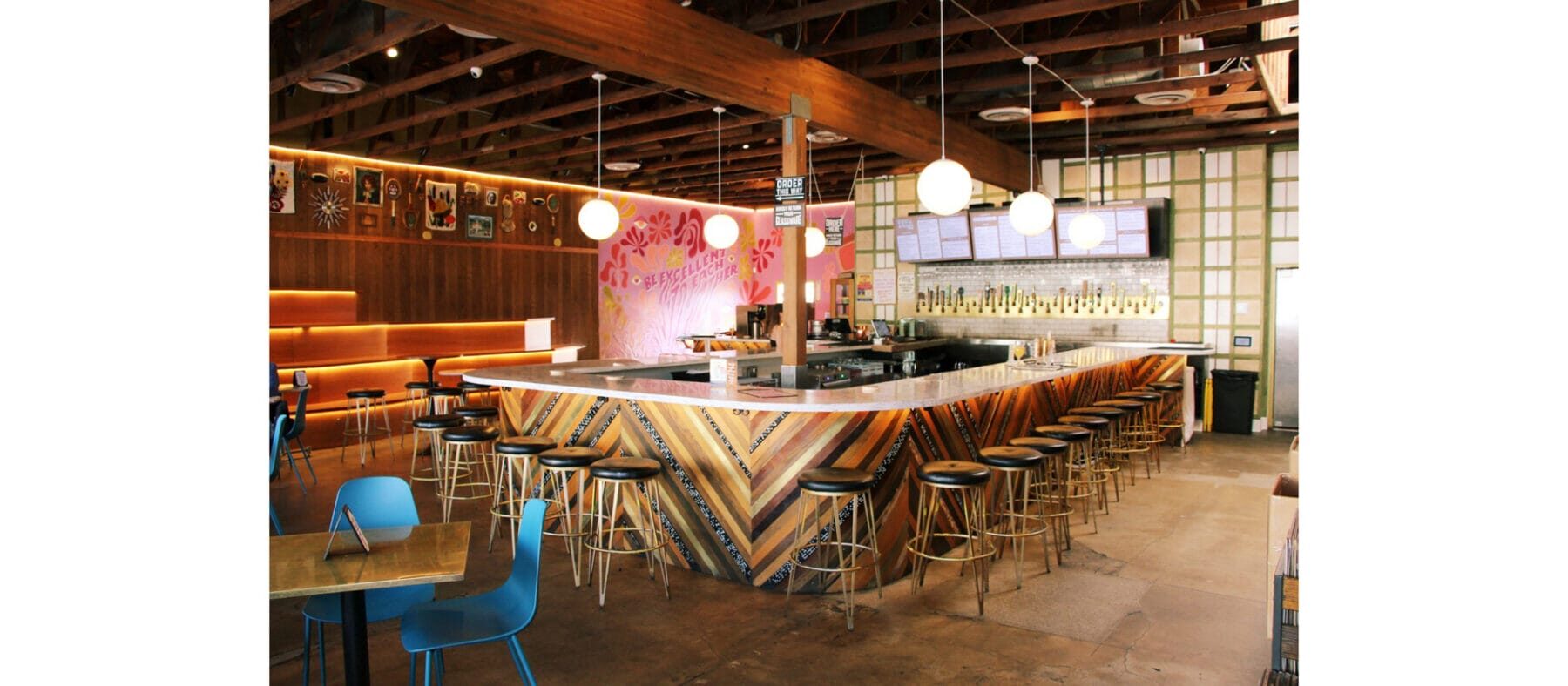 Interior view of a bar and restaurant with dark wood paneling and funky colors