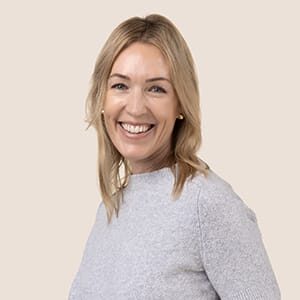 Blonde woman smiling wearing gray top