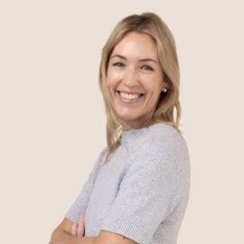 Blonde woman smiling wearing gray top