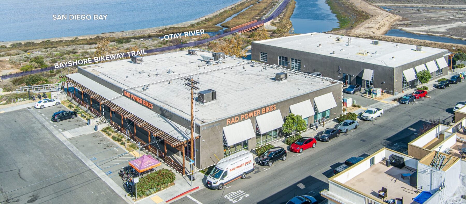 Aerial view of the building at 535 Florence St with the Bayshore Bikeway Trail, Otay River, and San Diego Bay just behind it.